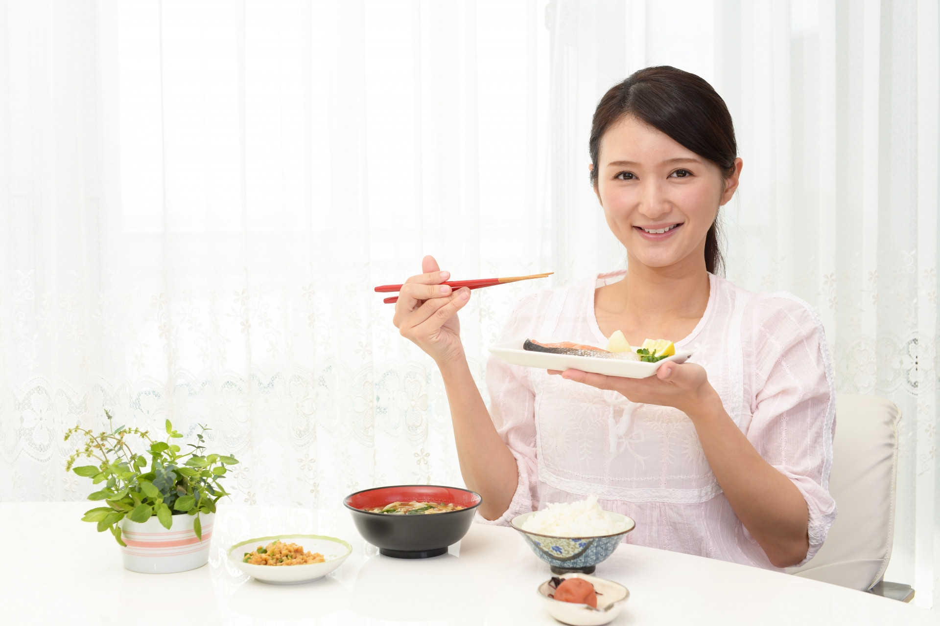 ご飯を食べる女性の写真